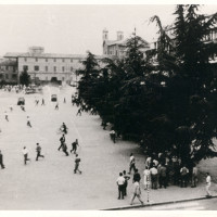 Un momento degli scontri fra forze dell'ordine e dimostranti in piazza della Vittoria il 7 luglio 1960. L'immagine è stata scattata dal balcone del teatro Ariosto. Sullo sfondo si riconoscono il palazzo dei civici musei e, a sinistra, il teatrto Romolo Valli